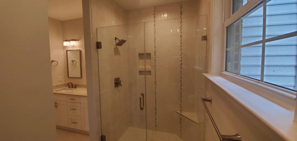 Modern bathroom with a walk-in shower, stylish fixtures, and natural light from a window.